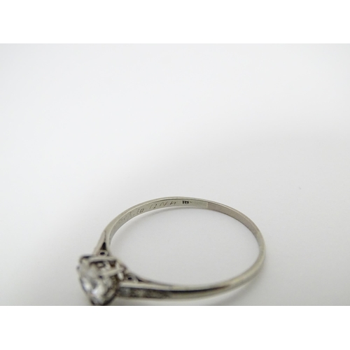 662 - A 18ct white gold ring set with diamond solitaire ring flanked by 3 diamonds to the shoulders. Ring ... 