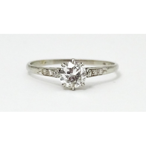 662 - A 18ct white gold ring set with diamond solitaire ring flanked by 3 diamonds to the shoulders. Ring ... 