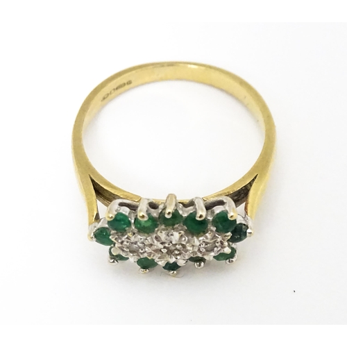 665 - A 9ct gold ring set with emeralds and diamonds. Ring size approx K 1/2