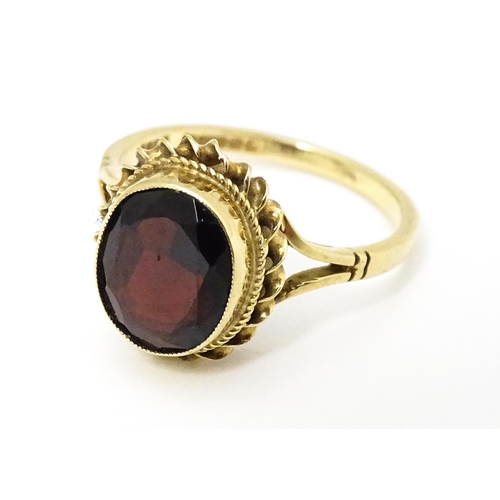 667 - A 9ct gold ring set with central garnet. Ring size approx M