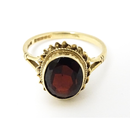 667 - A 9ct gold ring set with central garnet. Ring size approx M