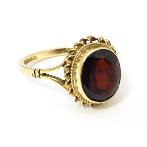 667 - A 9ct gold ring set with central garnet. Ring size approx M