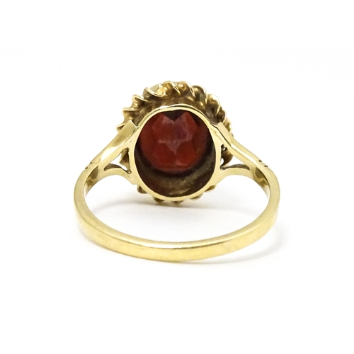 667 - A 9ct gold ring set with central garnet. Ring size approx M