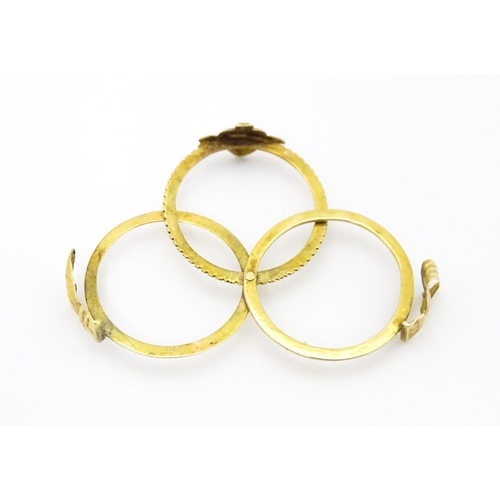 668 - A yellow metal gimmal / gimmel ring the three bands uniting as one, with a pair of interlocking hand... 