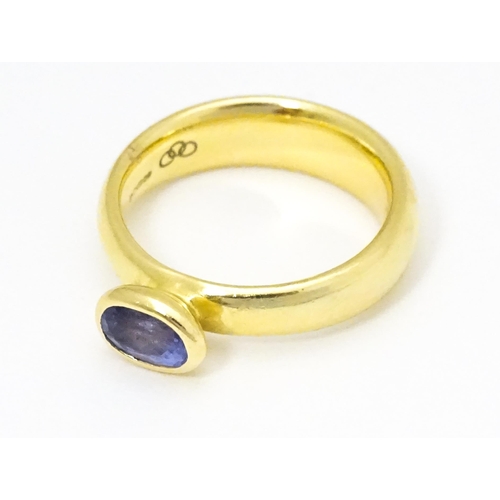 672 - An 18ct gold ring set with oval tanzanite, maker Links of London. Ring size approx M