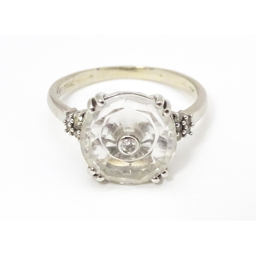 673 - A 10k white gold Lehrer Torus ring set with Bahia quartz and central diamond. Ring size approx M