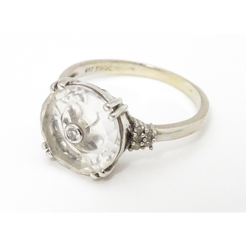 673 - A 10k white gold Lehrer Torus ring set with Bahia quartz and central diamond. Ring size approx M