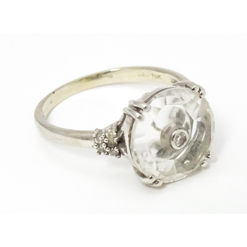 673 - A 10k white gold Lehrer Torus ring set with Bahia quartz and central diamond. Ring size approx M