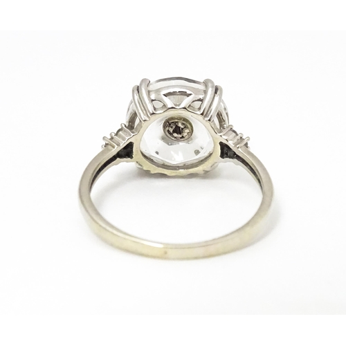 673 - A 10k white gold Lehrer Torus ring set with Bahia quartz and central diamond. Ring size approx M