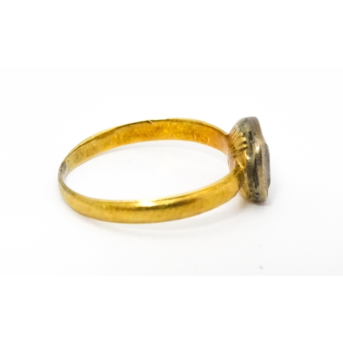 674 - A 19thC yellow metal ring set with central white stone. Ring size approx J