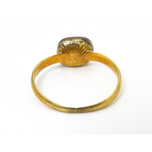 674 - A 19thC yellow metal ring set with central white stone. Ring size approx J