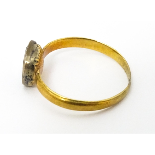 674 - A 19thC yellow metal ring set with central white stone. Ring size approx J