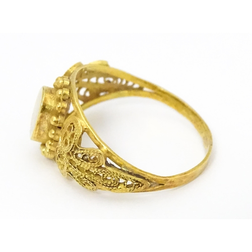 680 - A yellow metal ring with filigree decoration. Ring size approx. K 1/2