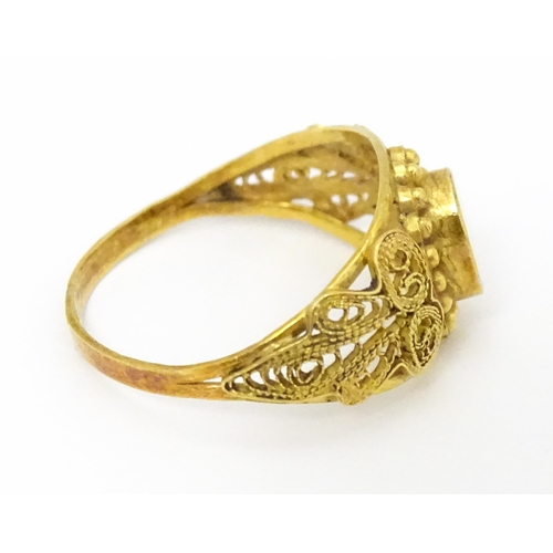 680 - A yellow metal ring with filigree decoration. Ring size approx. K 1/2