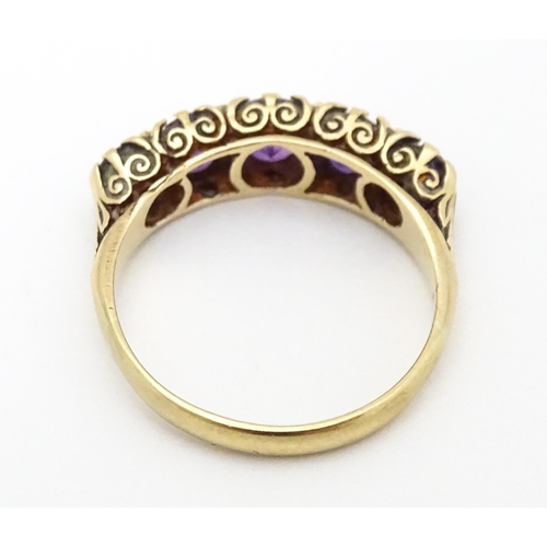 682 - A 9ct gold ring set with 5 graduated amethysts. Ring size approx L 1/2