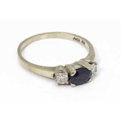 683 - An 18ct white gold ring set with central sapphire flanked by diamonds. Ring size approx. M 1/2