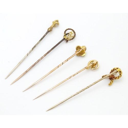 700 - Five assorted gold and gilt metal stick pins set with seed pearls, to include an example stamped 15c... 