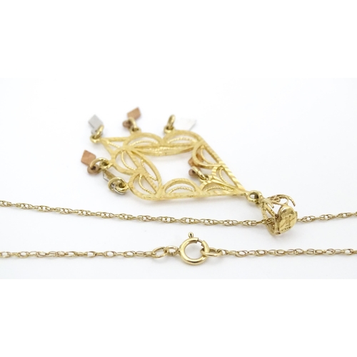 704 - A 9ct gold pendant with filigree detail on a 9ct gold chain. The pendant approx 2