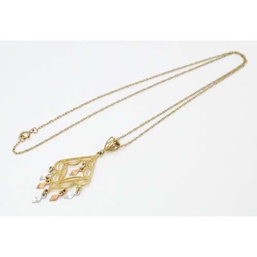 704 - A 9ct gold pendant with filigree detail on a 9ct gold chain. The pendant approx 2