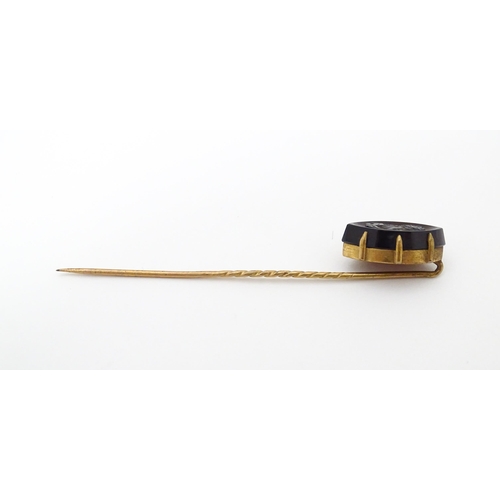 707 - A yellow metal stick pin with carved intaglio to top. Approx 2 3/4