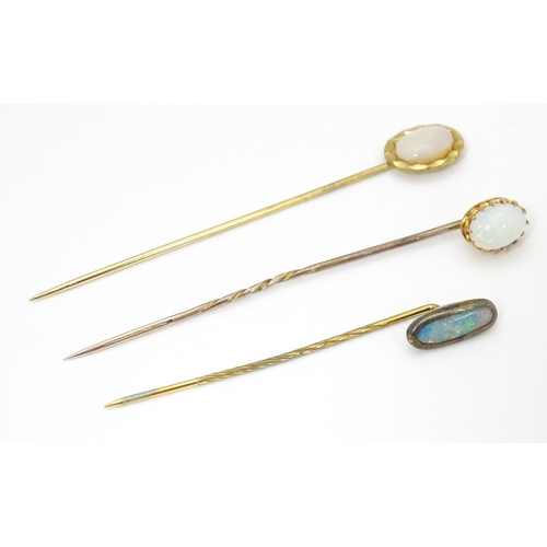 709 - Three gilt metal stick pins set with opal cabochon. The longest 2 1/2