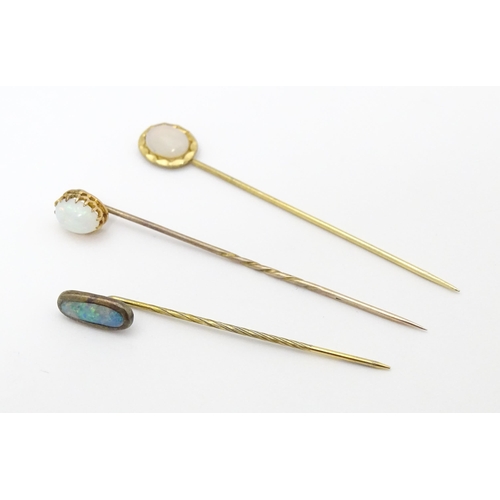 709 - Three gilt metal stick pins set with opal cabochon. The longest 2 1/2