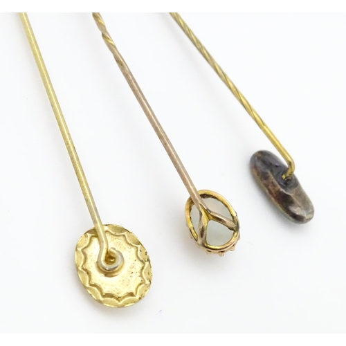 709 - Three gilt metal stick pins set with opal cabochon. The longest 2 1/2