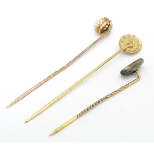 709 - Three gilt metal stick pins set with opal cabochon. The longest 2 1/2