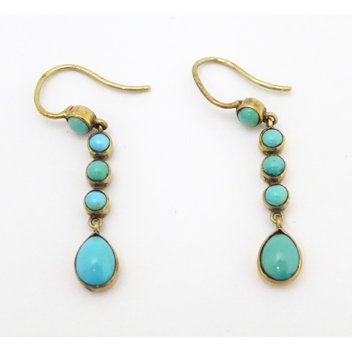 713 - A pair of gold drop earrings set with turquoise. 1 1 /4