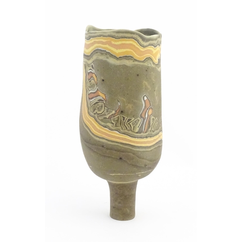 93 - A studio pottery slender footed vase by Mal Magson (b. 1950) with neriage decoration. Makers mark to... 