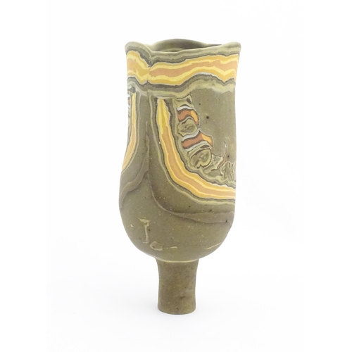 93 - A studio pottery slender footed vase by Mal Magson (b. 1950) with neriage decoration. Makers mark to... 