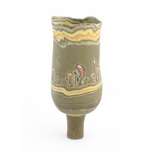 93 - A studio pottery slender footed vase by Mal Magson (b. 1950) with neriage decoration. Makers mark to... 