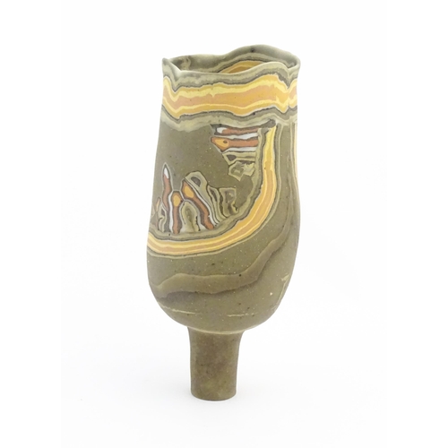 93 - A studio pottery slender footed vase by Mal Magson (b. 1950) with neriage decoration. Makers mark to... 