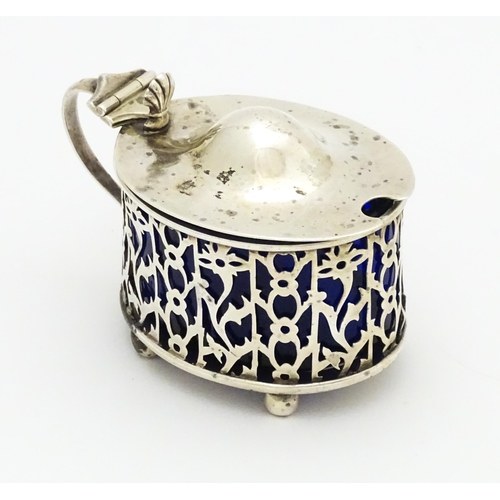 386 - A silver mustard pot with blue glass liner. Hallmarked Birmingham 1900, maker Deakin & Francis