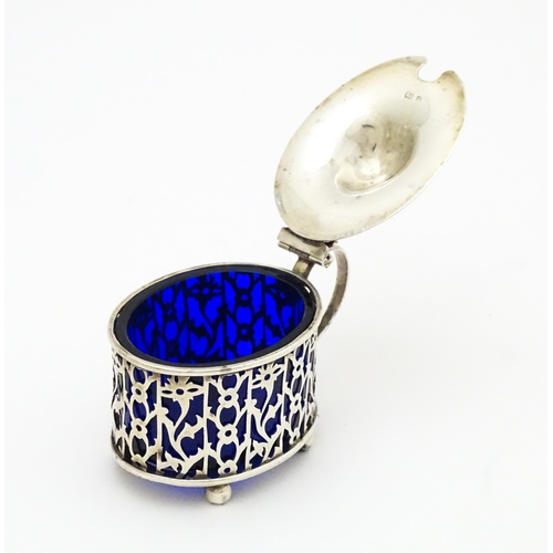 386 - A silver mustard pot with blue glass liner. Hallmarked Birmingham 1900, maker Deakin & Francis