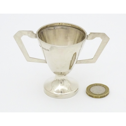 405 - An Art Deco silver trophy cup with twin handles. Hallmarked Birmingham 1937 maker David Hollander & ... 