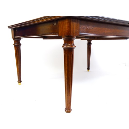 1433 - A late 20thC mahogany dining table with two additional leaves. The moulded table top raised on four ... 