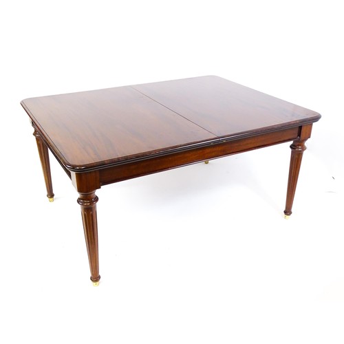 1433 - A late 20thC mahogany dining table with two additional leaves. The moulded table top raised on four ... 