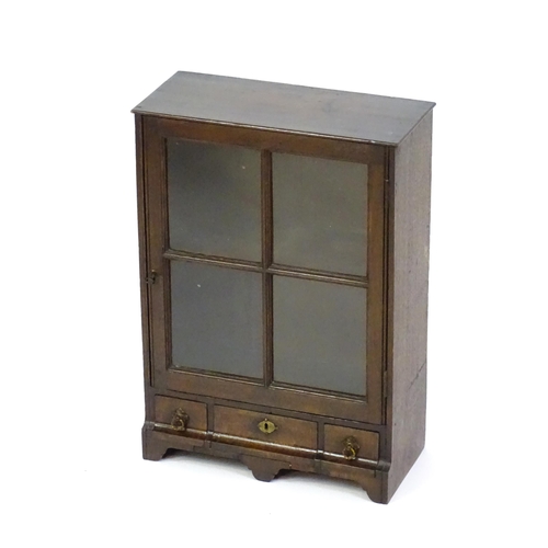 1442 - A late Georgian table top cabinet with an astragal glazed door above three short drawers raised on s... 