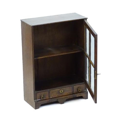 1442 - A late Georgian table top cabinet with an astragal glazed door above three short drawers raised on s... 