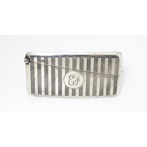 408 - A silver card case of shaped form with hinged lid and engine turned decoration. Hallmarked Chester 1... 