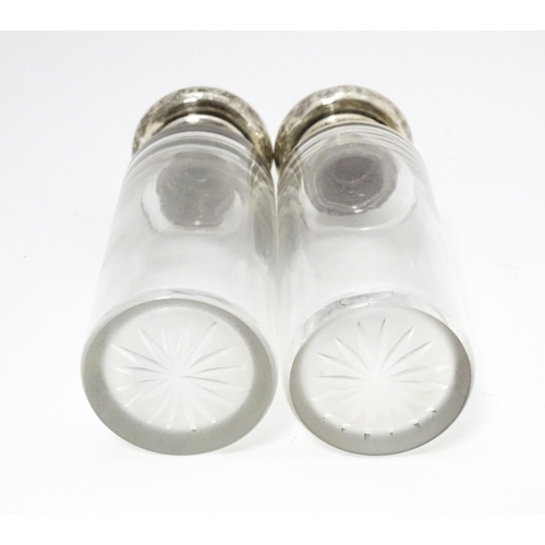 416 - A pair of glass dressing table jars with silver lids, hallmarked London 1906. Approx. 5