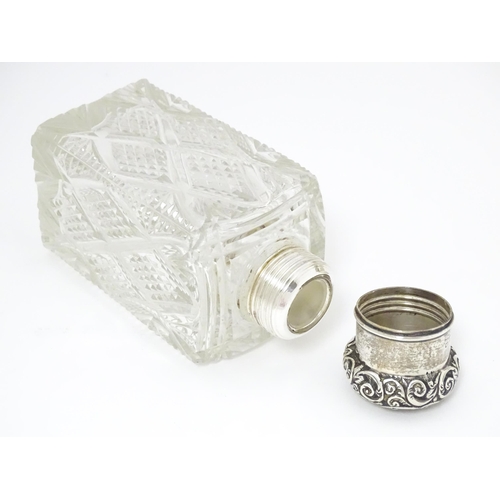 454 - A cut glass silver dressing table bottle of squared form with embossed silver lid.  Together with a ... 