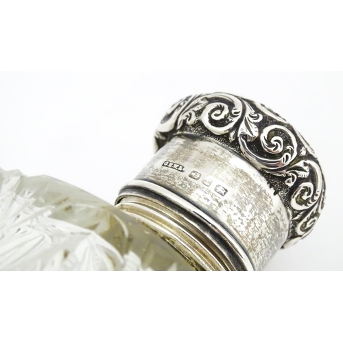 454 - A cut glass silver dressing table bottle of squared form with embossed silver lid.  Together with a ... 