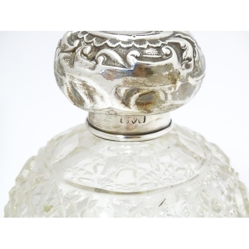 454 - A cut glass silver dressing table bottle of squared form with embossed silver lid.  Together with a ... 