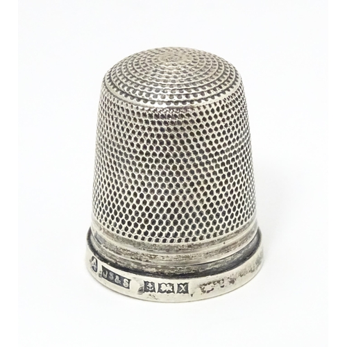 464 - A silver thimble hallmarked 1972 maker James Swann & Son together with a silver folding fruit knife ... 