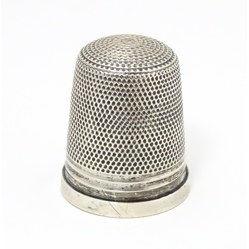 464 - A silver thimble hallmarked 1972 maker James Swann & Son together with a silver folding fruit knife ... 