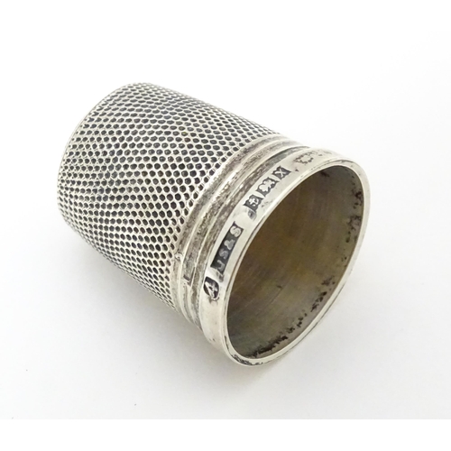 464 - A silver thimble hallmarked 1972 maker James Swann & Son together with a silver folding fruit knife ... 