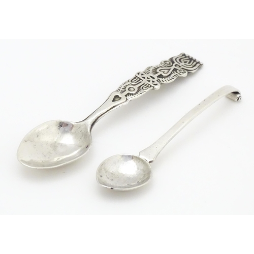 502 - A white metal Arts & Crafts teaspoon with hammered bowl and scroll detail to handle. Together with a... 