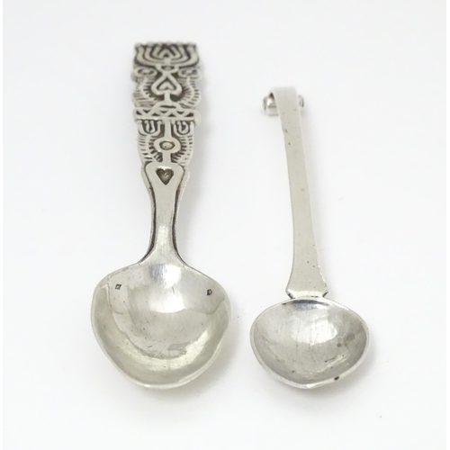 502 - A white metal Arts & Crafts teaspoon with hammered bowl and scroll detail to handle. Together with a... 